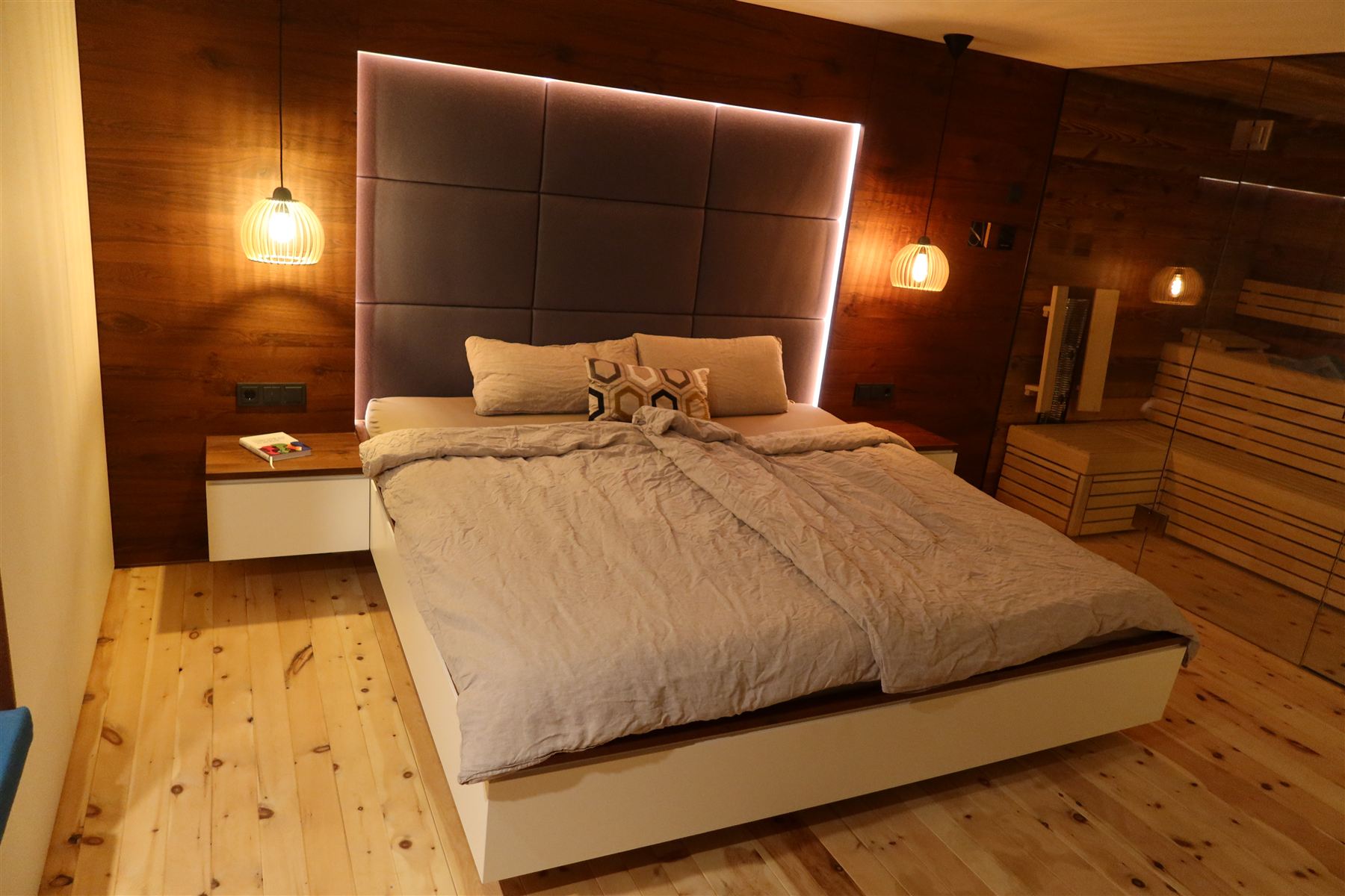 Individuell gestaltetes Schlafzimmer mit Holzverkleidung